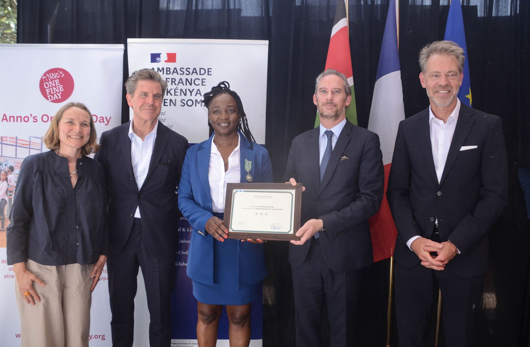 Krysteen Savane receives the Chevalier insignia from French Ambassador Arnaud Suquet in Kibera